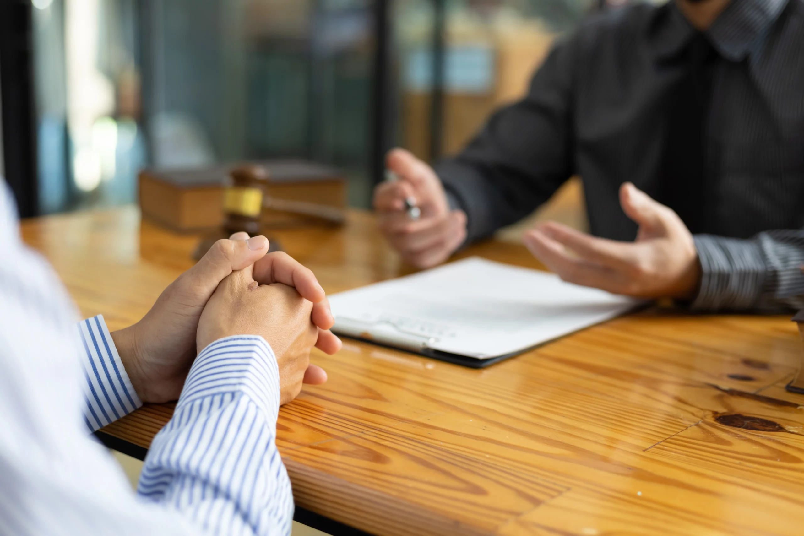 Two individuals discussing immigration rights in a professional setting with clipboard on table.
